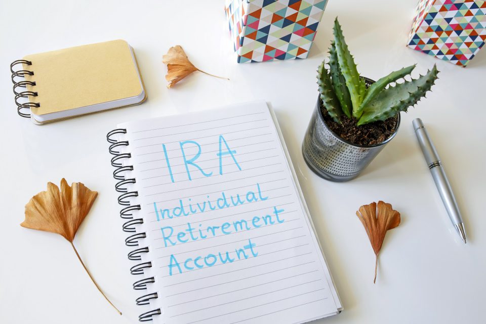 IRA Individual Retirement Account written in a notebook on white table