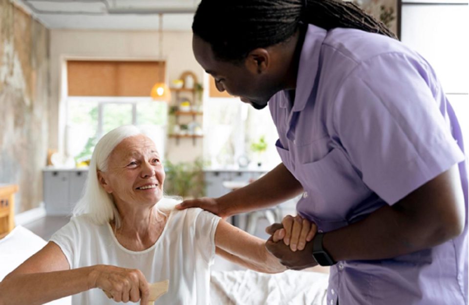 Staff at nursing home assisting happy senior woman